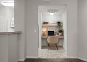 Thumbnail 11 of 57 - Built-in desk nook with overhead shelf, workspace lighting, and seating area located just off the kitchen in a Crescent Apartments unit.