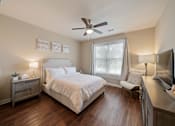 Thumbnail 43 of 50 - Guest suite bedroom at The Dorset featuring a queen bed, nightstand, window with natural light, and wood-style flooring