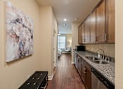 Thumbnail 46 of 50 - Guest suite kitchenette at The Dorset with granite countertops, wood cabinetry, sink, and appliance space