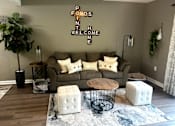 Thumbnail 4 of 14 - A living room with a couch, a table, and a plant.