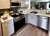 Thumbnail 2 of 14 - A kitchen with a black stove top oven and white cabinets.