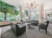 Thumbnail 3 of 19 - A large room with a chandelier and a view of trees outside the windows.