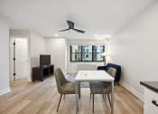 Thumbnail 9 of 37 - a living room with a white table and chairs and a tv