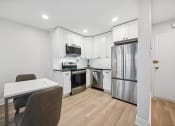 Thumbnail 7 of 37 - a white kitchen with stainless steel appliances and white cabinets