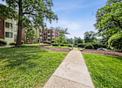 Thumbnail 27 of 27 - a grassy area with trees and buildings in the background
