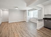 Thumbnail 14 of 27 - an empty kitchen and living room with wood flooring and a large window