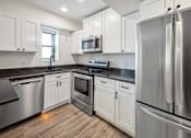 Thumbnail 15 of 27 - a kitchen with stainless steel appliances and white cabinets