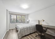 Thumbnail 23 of 37 - a bedroom with a bed and a desk and a window
