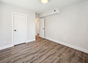Thumbnail 17 of 27 - an empty room with white walls and wood flooring