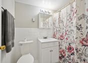 Thumbnail 30 of 37 - a bathroom with a shower curtain and a toilet and a sink