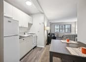 Thumbnail 21 of 37 - a kitchen and living room with white appliances and a wooden table