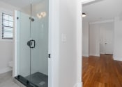 Thumbnail 13 of 22 - a bathroom with a glass shower and a wooden floor
