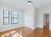Thumbnail 5 of 22 - a living room with wood floors and a white door and window
