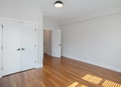 Thumbnail 3 of 22 - an empty living room with white doors and wood flooring