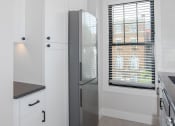Thumbnail 16 of 22 - a kitchen with white cabinets and a stainless steel refrigerator