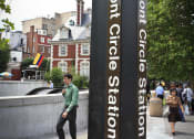 Thumbnail 14 of 16 - a man talking on a cell phone next to a sign