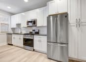 Thumbnail 7 of 22 - a white kitchen with stainless steel appliances and white cabinets