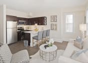 Thumbnail 6 of 20 - a living room and kitchen with a white couch and a table