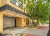 Thumbnail 2 of 37 - a building with a garage door and trees in front of it