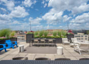 Thumbnail 32 of 37 - a rooftop patio with tables and chairs and a view of the city