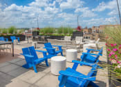 Thumbnail 33 of 37 - an outdoor patio with blue chairs and tables on a sunny day