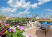 Thumbnail 35 of 37 - a rooftop patio with tables and chairs and flowers