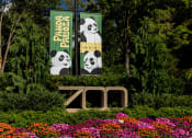 Thumbnail 25 of 34 - a sign for the zoo in front of some flowers