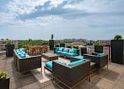 Thumbnail 12 of 18 - A patio with wicker furniture and blue cushions.