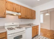 Thumbnail 16 of 19 - a kitchen with white appliances and wooden cabinets and a white stove
