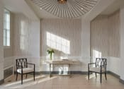 Thumbnail 3 of 20 - a lobby with a table and chairs and a large chandelier