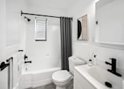 Thumbnail 8 of 27 - a bathroom with a white sink and toilet next to a bathtub with a shower curtain