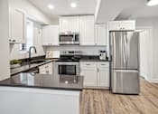 Thumbnail 6 of 27 - a kitchen with white cabinets and stainless steel appliances