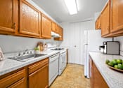 Thumbnail 9 of 19 - A kitchen with wooden cabinets and a white refrigerator.