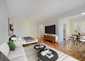 Thumbnail 8 of 15 - A modern living room with a grey sofa, a black coffee table, and a television.
