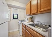 Thumbnail 20 of 27 - a kitchen with white appliances and wooden cabinets and a sink