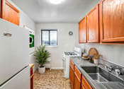 Thumbnail 4 of 7 - A small kitchen with a white fridge and a window.