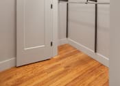 Thumbnail 9 of 35 - A white closet with a wooden floor and a metal rack.