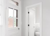 Thumbnail 14 of 22 - a white bathroom with a white door and a white toilet