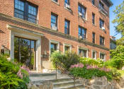 Thumbnail 3 of 22 - the front of a brick building with stairs and plants