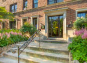 Thumbnail 2 of 22 - the front of a brick building with stairs and a glass door