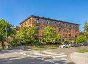 Thumbnail 1 of 22 - a large brick building on the corner of a street