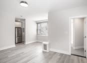 Thumbnail 13 of 35 - empty living room with a large window and a door to a kitchen