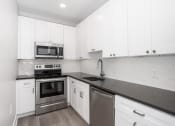 Thumbnail 14 of 35 - white kitchen with stainless steel appliances and white cabinets