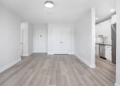 Thumbnail 15 of 35 - empty living room with a kitchen in the background