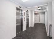 Thumbnail 8 of 41 - a hallway with stainless steel elevators and white walls