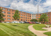 Thumbnail 2 of 7 - a large brick building with a park in front of it