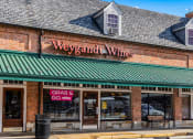 Thumbnail 20 of 22 - a brick building with a green roof and a sign that reads wines
