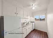 Thumbnail 1 of 17 - A kitchen with white cabinets and a window overlooking the beach.