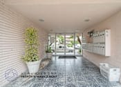 Thumbnail 17 of 17 - A hallway with a plant and a sign for Beach Front Property Management.
