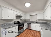 Thumbnail 2 of 32 - A kitchen with white cabinets and a granite countertop.
